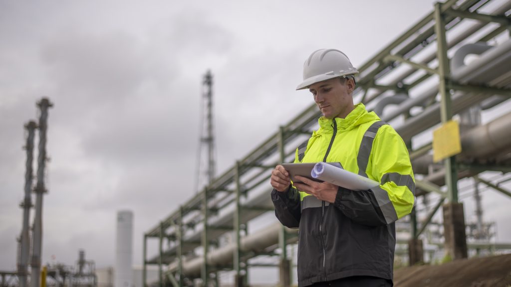 Ingeniero industrial revisando documentación técnica en una planta energética europea.